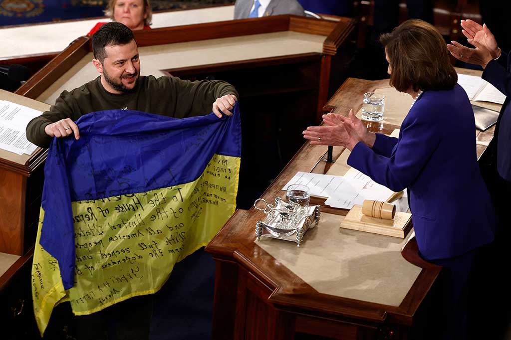 Presiden Volodymyr Zelensky memberikan bendera pertempuran Ukraina kepada Ketua Parlemen AS Nancy Pelosi setelah berpidato di sesi bersama Kongres pada hari Rabu, 21 Desember 2022 waktu setempat.
