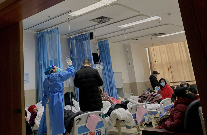 Dengan tabung pernapasan di bawah tumpukan selimut, seorang lelaki tua yang menderita Covid-19 terbaring mengerang di atas tandu di unit gawat darurat sebuah rumah sakit di China tengah.