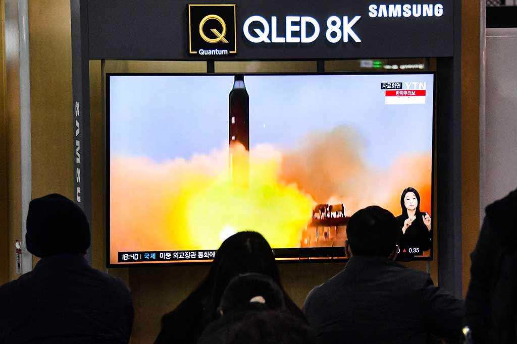 Orang-orang menonton layar televisi yang menayangkan siaran berita dengan rekaman file uji coba rudal Korea Utara, di sebuah stasiun kereta api di Seoul pada Jumat, 23 Desember 2022.