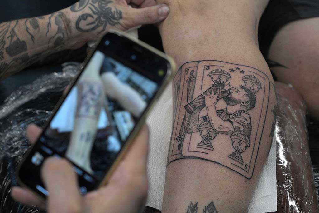 Euforia keberhasilan timnas Argentina juara Piala Dunia 2022 Qatar masih terus berlangsung. Para fan mengantre untuk merajah tubuh mereka dengan wajah sang kapten Lionel Messi dan trofi Piala Dunia di Buenos Aires.