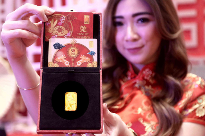 Model menunjukkan emas batangan edisi khusus Imlek shio kelinci saat peluncuran produk tersebut di Jakarta, Kamis, 5 Januari 2023.