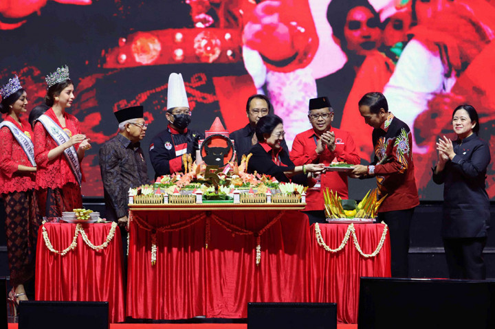 Jokowi menerima tumpengan itu dengan senyum dan sedikit menundukkan kepalanya. Tumpeng berikutnya kepada Wapres. 
