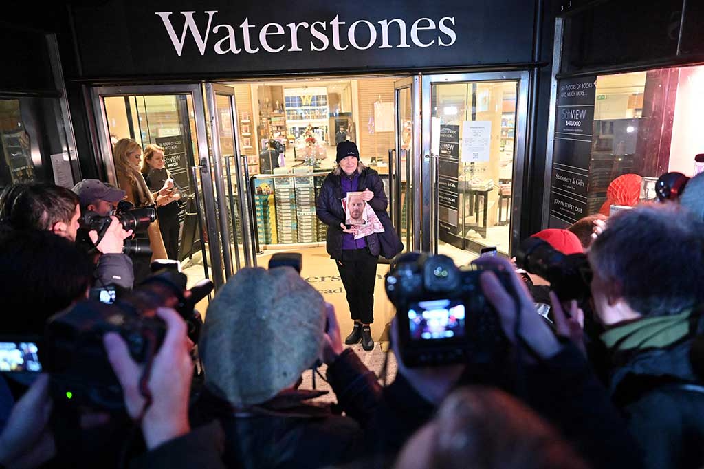 Caroline Lennon, pelanggan pertama yang membeli 'Spare' karya Pangeran Inggris Harry, Duke of Sussex, berpose dengan salinannya di depan media di luar toko buku Waterstones di Piccadilly, London pada Selasa, 10 Januari 2023.