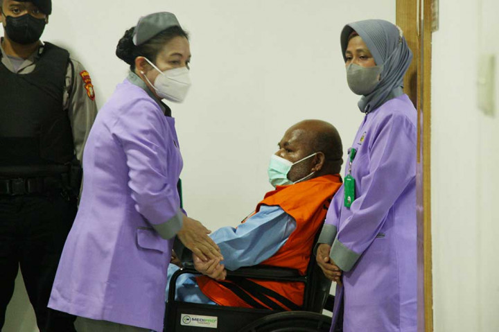 Saat jumpa pers, KPK turut menghadirkan Lukas Enembe yang telah menggunakan rompi tahanan. Selain itu, yang bersangkutan menggunakan kursi roda dikawal dengan petugas KPK.