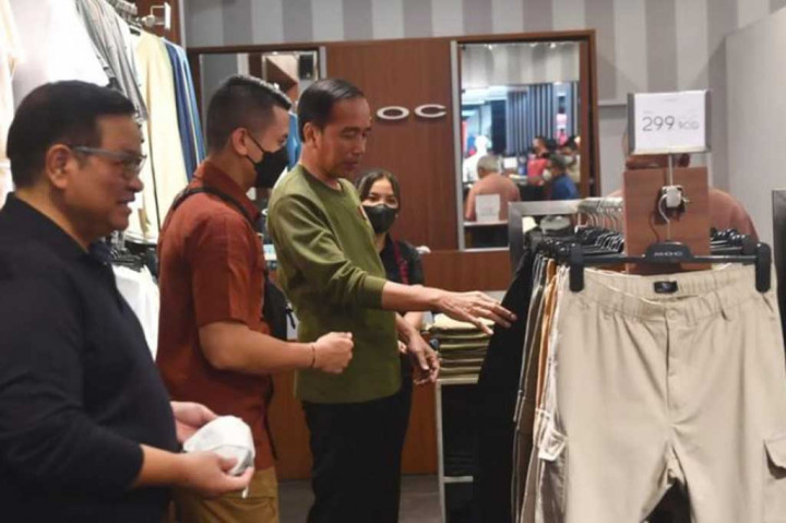 Presiden Jokowi kemudian memilih-milih pakaian yang dipajang di toko tersebut.