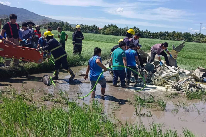 Proses evakuasi pilot korban kecelakaan udara pesawat militer SF260 Marchetti  yang jatuh ke sawah.