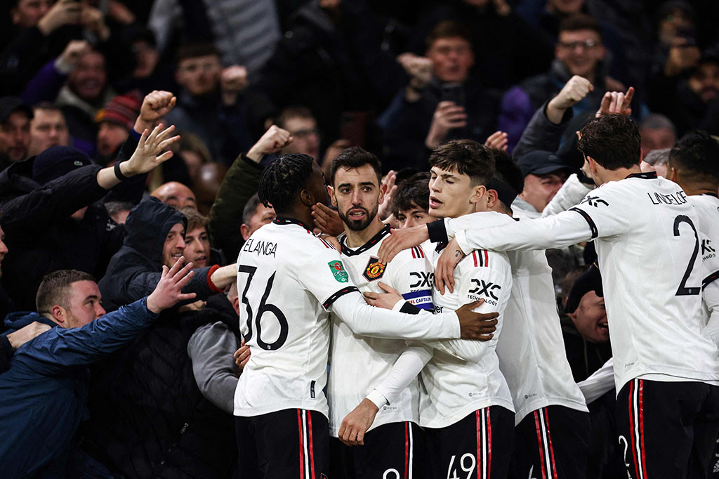 Para pemain MU merayakan selebrasi atas cetakan gol ketiga timnya di samping sorak-sorai pendukung selama pertandingan sepak bola leg pertama semifinal Piala Liga Inggris.