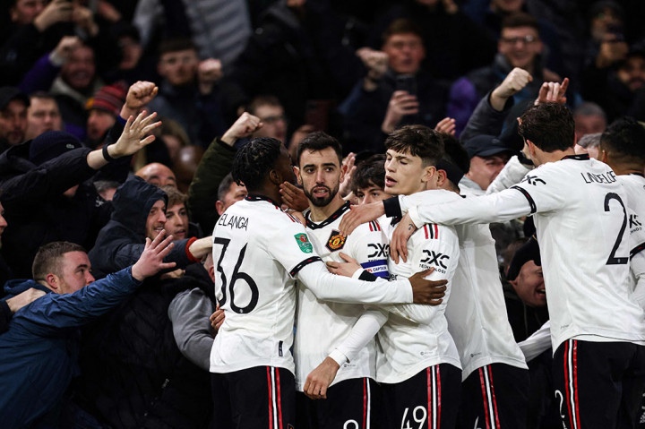 Para pemain MU merayakan selebrasi atas cetakan gol ketiga timnya di samping sorak-sorai pendukung selama pertandingan sepak bola leg pertama semifinal Piala Liga Inggris.
