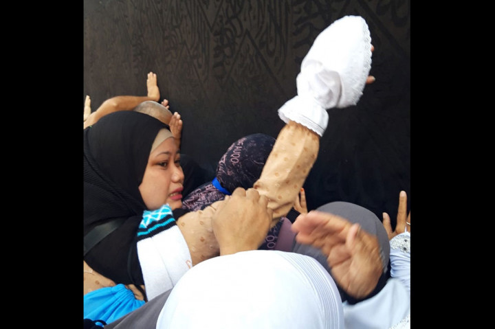 Seorang jemaah menangis haru saat bisa menyentuh Kakbah.