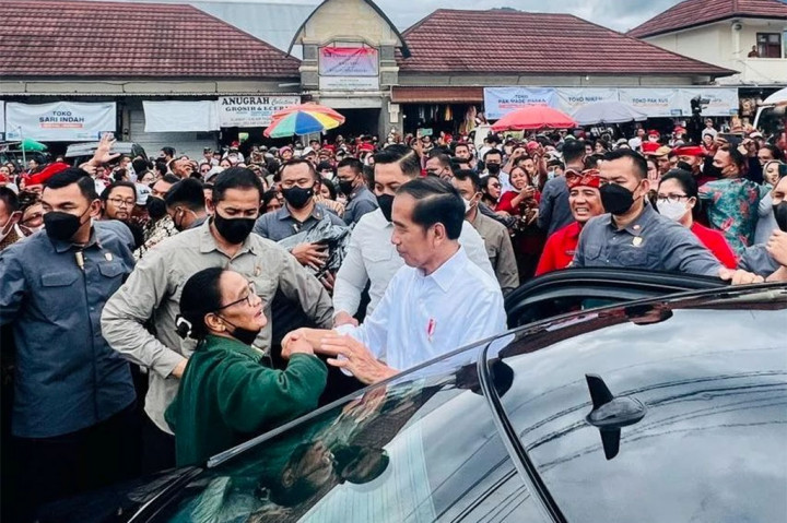 Sebelum meninggalkan pasar, Jokowi membagikan kaus berwarna hitam bergambar wajahnya kepada para pedagang dan masyarakat.