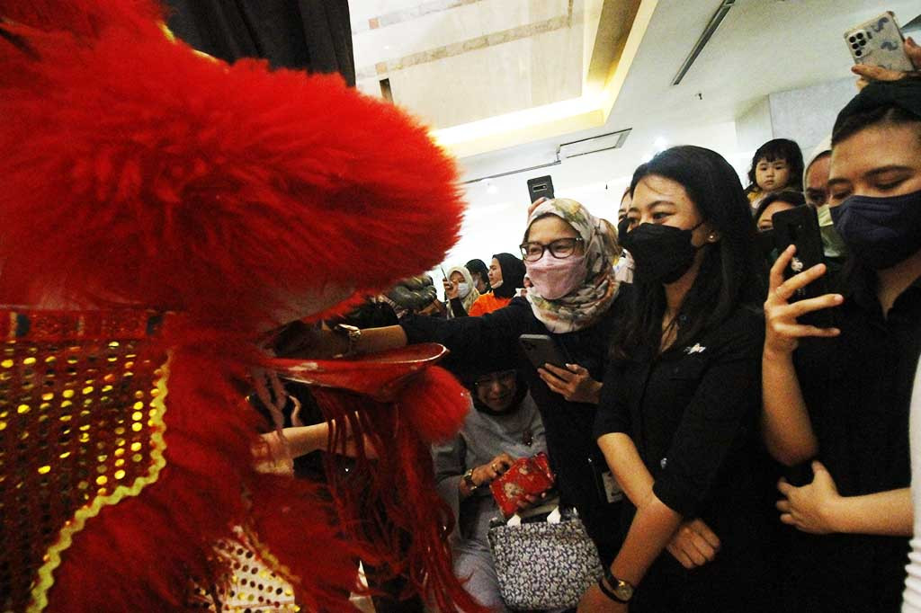 Penonton menyelipkan angpao kepada barongsai di depannya.