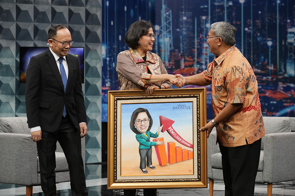 Redaksi Media Group Elman Saragih (kanan) memberikan gambar karikatur kepada Menteri Keuangan Sri Mulyani disaksikan Direktur Pemberitaan Media Indonesia Ade Alawi seusai Kuliah Umum di Grand Studio Metro TV.