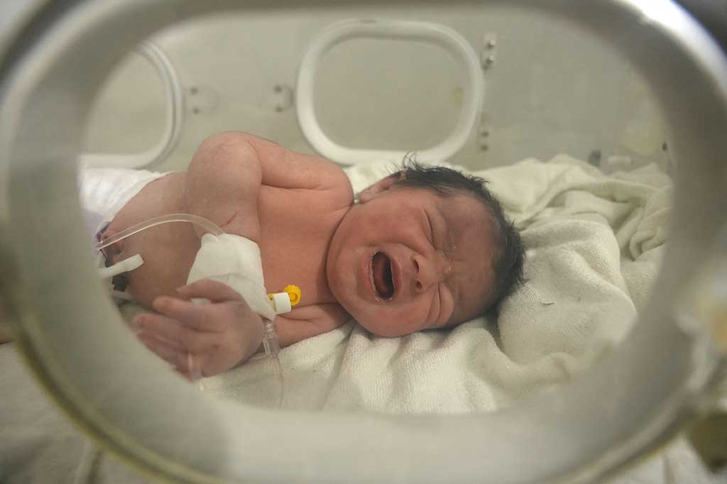 Bayi tersebut ditemukan hidup dan masih terikat tali pusar dengan ibunya yang meninggal dalam gempa tersebut.