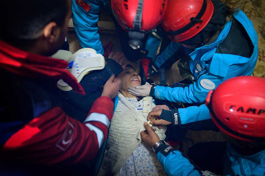 Seorang perempuan diselamatkan dari reruntuhan bangunan yang hancur di Hatay, Suriah, Minggu, 12 Februari 2023. Sepekan setelah salah satu gempa bumi terburuk yang melanda Turki dan Suriah, tim penyelamat menemukan lebih banyak korban selamat dari reruntuhan.