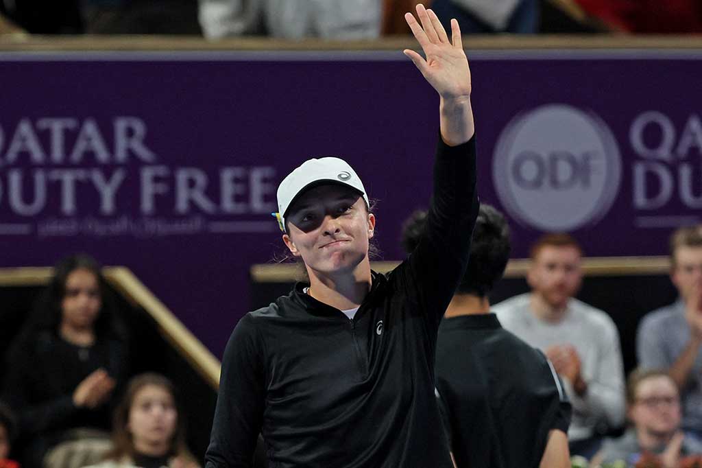 Petenis nomor satu dunia Iga Swiatek melambaikan tangan ke arah penonton usai melaju mudah ke perempat final turnamen Qatar Open, Rabu, 15 Februari 2023.