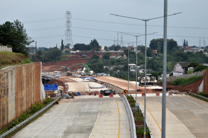 Pekerja dibantu alat berat mengerjakan pembangunan jalan Tol Serpong-Cinere di ruas Pamulang-Cinere di Pamulang, Tangerang Selatan, Banten. Proyek pembangunan tol tersebut hingga kini terus dikebut.
