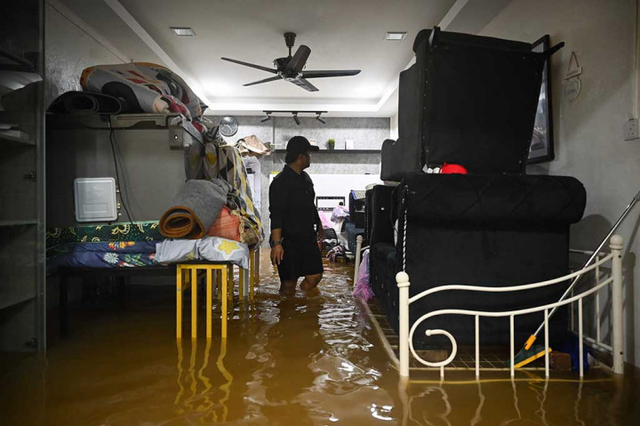 Seorang pria mengamankan perabot rumahnya dari jangkauan air sebelum dievakuasi dari daerah banjir di Yong Peng, negara bagian Johor, Malaysia pada Sabtu, 4 Maret 2023.