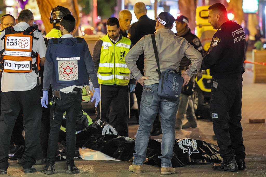 Polisi dan paramedis Israel berdiri di dekat jenazah di lokasi serangan penembakan di sepanjang Dizengoff Avenue, Tel Aviv pada Kamis, 9 Maret 2023 waktu setempat. 