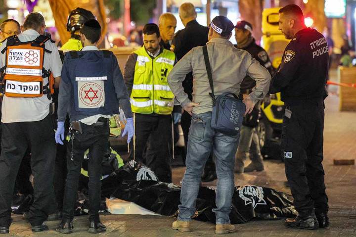 Polisi dan paramedis Israel berdiri di dekat jenazah di lokasi serangan penembakan di sepanjang Dizengoff Avenue, Tel Aviv pada Kamis, 9 Maret 2023 waktu setempat. 