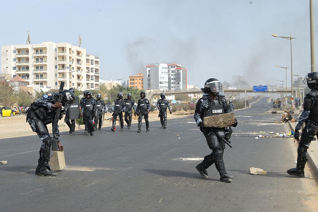Dia dibawa dari rumahnya di ibu kota Dakar Kamis pagi di bawah pengawalan ketat polisi setelah dikurung di sana pada malam persidangan saat pihak berwenang bersiap menghadapi protes.
