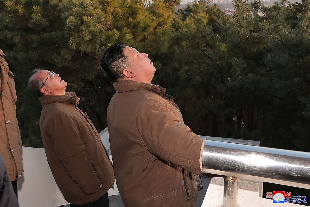 Foto-foto di surat kabar resmi Rodong Sinmun menunjukkan Kim menyaksikan Hwasong-17 hitam-putih - dijuluki 'rudal monster' oleh para analis - meluncur ke langit.