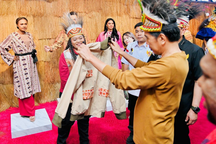 Presiden Joko Widodo meninjau sejumlah stan produk yang dihasilkan oleh para pemuda Papua di Papua Youth Creative Hub (PYCH), Jayapura, pada Selasa, 21 Maret 2023. Dalam peninjauan tersebut, Presiden mendapat hadiah berupa jaket dari seorang perancang busana asli Papua, Eunike Yunita.