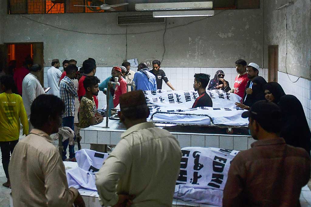 Kerabat berduka di samping jenazah korban yang meninggal dalam penyerbuan selama pembagian sedekah Ramadhan untuk orang yang membutuhkan, di sebuah rumah sakit di Karachi pada 31 Maret 2023.