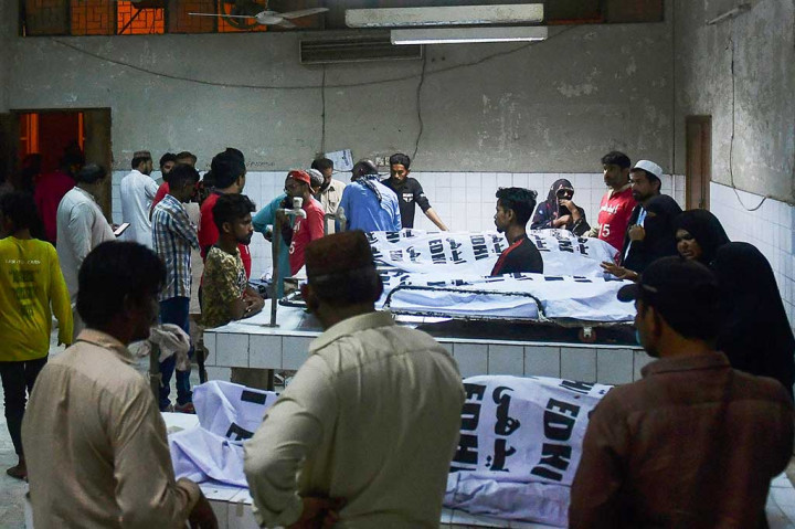 Kerabat berduka di samping jenazah korban yang meninggal dalam penyerbuan selama pembagian sedekah Ramadhan untuk orang yang membutuhkan, di sebuah rumah sakit di Karachi pada 31 Maret 2023.