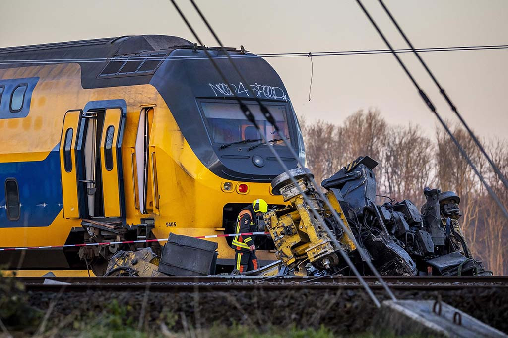 Satu gerbong tergantung di atas selokan kecil berisi air. Gerbong ketiga tetap tegak, sementara gerbong keempat terbakar, kata kantor berita ANP.