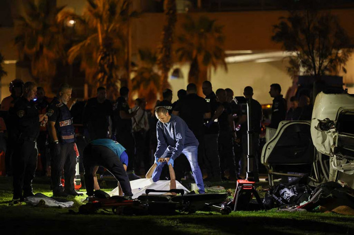 Polisi Israel memindahkan jenazah penyerang dari lokasi serangan menabrak mobil di Tel Aviv pada Jumat, 7 April 2023 waktu setempat. Pria tersebut dilumpuhkan setelah melakukan aksinya.