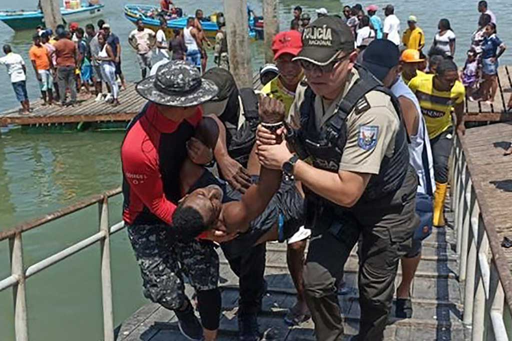 Anggota polisi mengevakuasi seorang pria yang terluka di pelabuhan perikanan di Esmeraldas, Ekuador, pada Selasa, 11 April 2023. Sembilan orang tewas setelah puluhan pria bersenjata yang tiba dengan perahu melepaskan tembakan ke sebuah pelabuhan di Ekuador utara dekat perbatasan Kolombia.