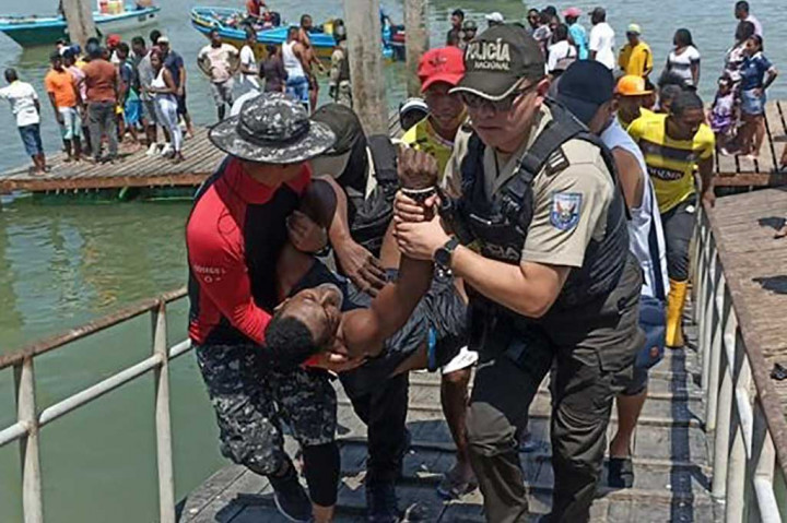 Anggota polisi mengevakuasi seorang pria yang terluka di pelabuhan perikanan di Esmeraldas, Ekuador, pada Selasa, 11 April 2023. Sembilan orang tewas setelah puluhan pria bersenjata yang tiba dengan perahu melepaskan tembakan ke sebuah pelabuhan di Ekuador utara dekat perbatasan Kolombia.