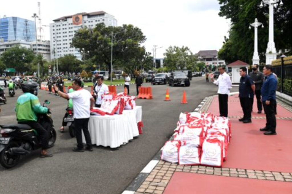 Presiden Jokowi didampingi Menteri Badan Usaha Milik Negara (BUMN) Erick Thohir tampak meninjau pembagian sembako tersebut sambil melambaikan tangan ke para pengemudi ojek yang sedang mengantre.