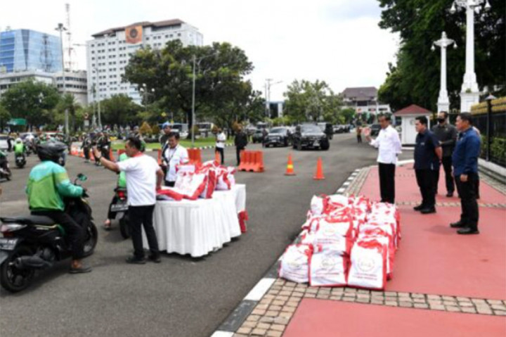 Presiden Jokowi didampingi Menteri Badan Usaha Milik Negara (BUMN) Erick Thohir tampak meninjau pembagian sembako tersebut sambil melambaikan tangan ke para pengemudi ojek yang sedang mengantre.