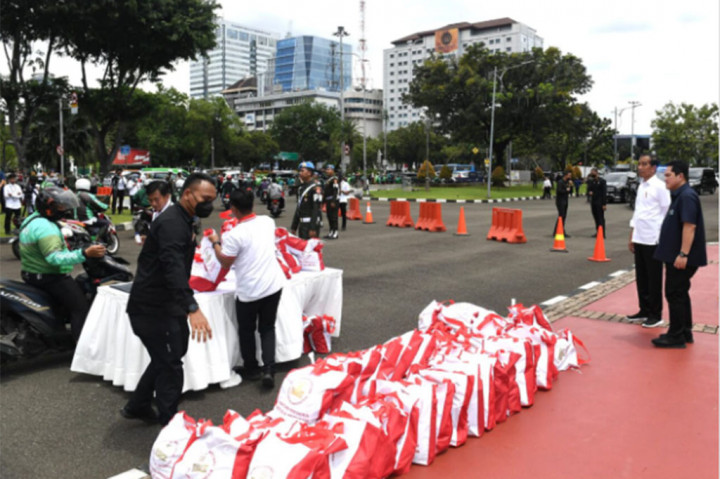 Presiden Joko Widodo membagikan paket sembako kepada ribuan pengemudi ojek daring (ojek online) dan ojek pangkalan yang melintas di sekitar Istana Merdeka, Jalan Medan Merdeka Utara, Jakarta Pusat, Kamis, 13 April 2023.