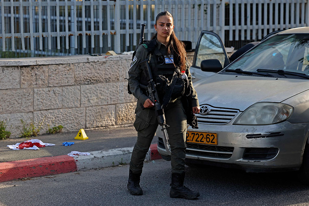 Seorang anggota pasukan keamanan Israel berjaga di lokasi serangan penembakan di lingkungan Sheikh Jarrah di Yerusalem timur yang dianeksasi, pada 18 April 2023. 