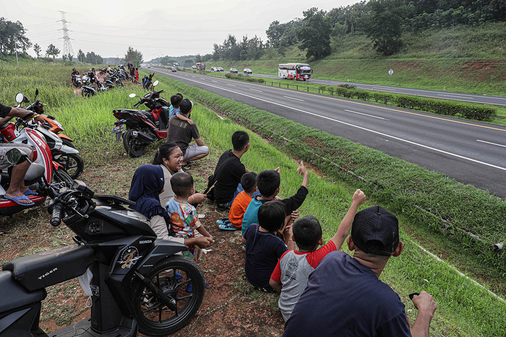 Warga menghabiskan waktu menunggu berbuka puasa (ngabuburit) dengan menonton kendaraan pemudik yang lewat saat pemberlakuan one way di Tol Cipali KM 78, Purwakarta, Selasa, 1 April 2023. Sambil membawa anak-anak, warga sekitar duduk di tepi-tepi Tol Cipali menonton volume kendaraan arus mudik yang mulai meningkat.
