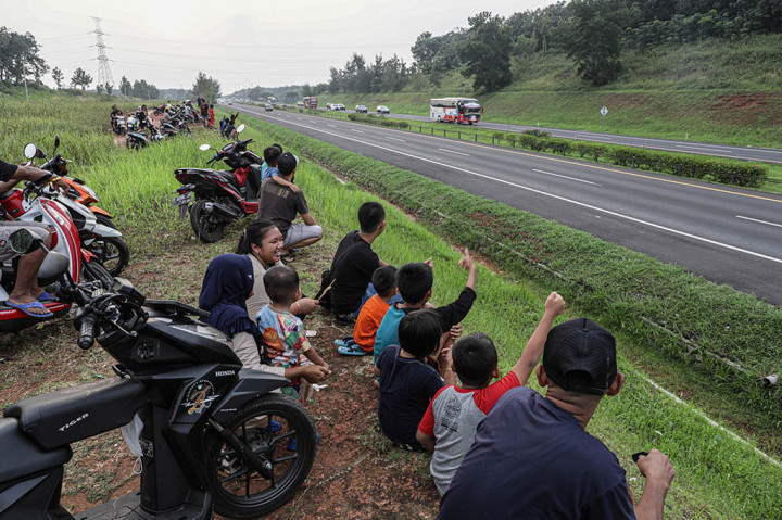 Warga menghabiskan waktu menunggu berbuka puasa (ngabuburit) dengan menonton kendaraan pemudik yang lewat saat pemberlakuan one way di Tol Cipali KM 78, Purwakarta, Selasa, 1 April 2023. Sambil membawa anak-anak, warga sekitar duduk di tepi-tepi Tol Cipali menonton volume kendaraan arus mudik yang mulai meningkat.