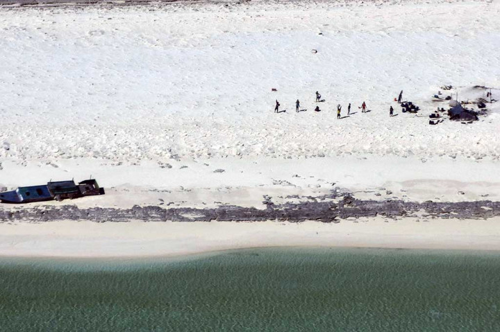 Foto yang dirilis Otoritas Keselamatan Maritim Australia (AMSA) pada Rabu, 19 April menunjukkan para nelayan Indonesia yang terdampar di Pulau Bedwell di lepas pantai barat Australia. 