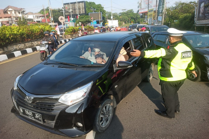 Anggota Polres Bogor bersama petugas Dinas Perhubungan (Dishub) Bogor mengarahkan kendaraan yang tidak sesuai aturan untuk memutar balik sesuai dengan nomor polisi saat diberlakukannya aturan ganjil-genap di Ciawi, Bogor, Jawa Barat, Minggu, 23 April 2023. 
