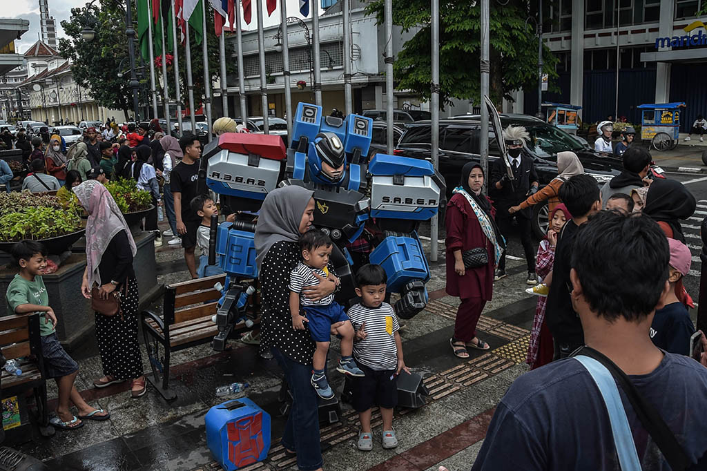 Wisatawan berfoto dengan sejumlah cosplayer yang ada di kawasan Jalan Asia Afrika, Kota Bandung, Jawa Barat, Minggu, 23 April 2023.