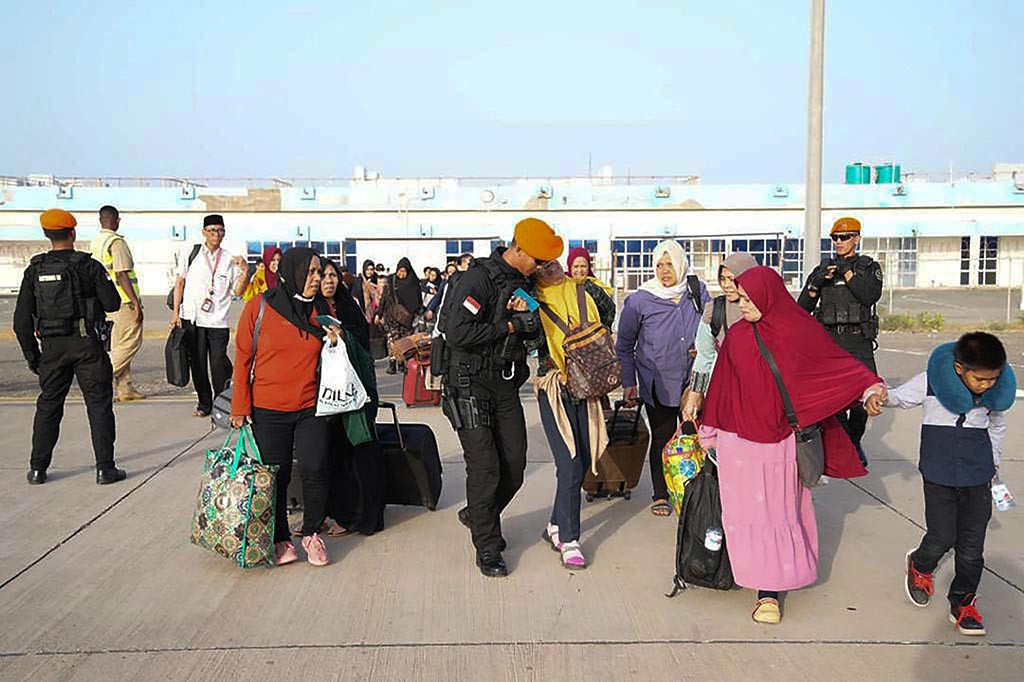 Personel Satbravo Kopasgat TNI AU membantu Warga Negara Indonesia (WNI) menaiki pesawat boeing 737 A-7305 TNI AU untuk diterbangkan menuju posko evakuasi di Jeddah, Arab Saudi, dari kota Port of Sudan, Rabu, 26 April 2023.