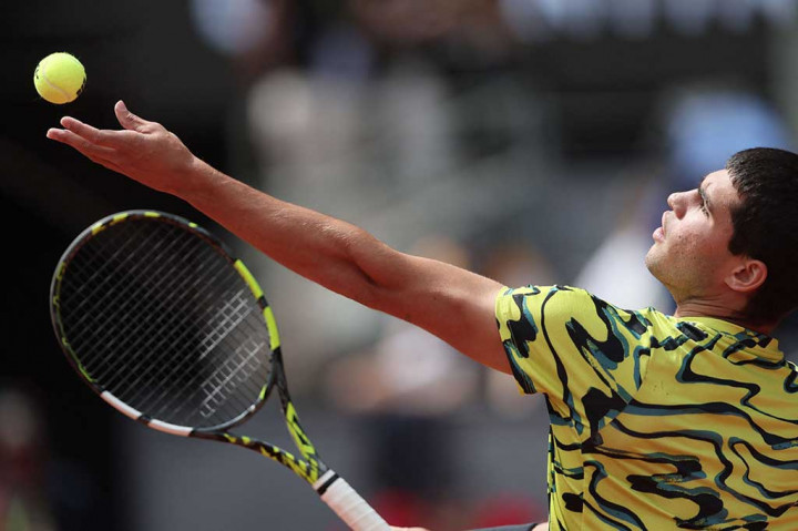 Carlos Alcaraz melancarkan servis ke arah lawannya Alexander Zverev pada laga 16 besar Madrid Open, di Caja Magica, Madrid, Selasa, 2 Mei 2023 waktu setempat.