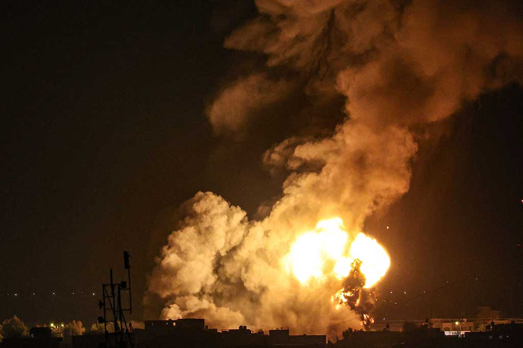 Asap dan api mengepul di atas gedung-gedung setelah serangan udara Israel di Rafah, Jalur Gaza selatan, pada Rabu, 3 Mei 2023.