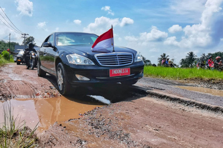 Mobil sedan yang dinaiki Presiden Joko Widodo terlihat melintasi jalan-jalan berlumbang di Jalan Terusan Ryacudu, Kota Baru, Jati Agung, Kabupaten Lampung Selatan, Lampung, Jumat, 5 Mei 2023.