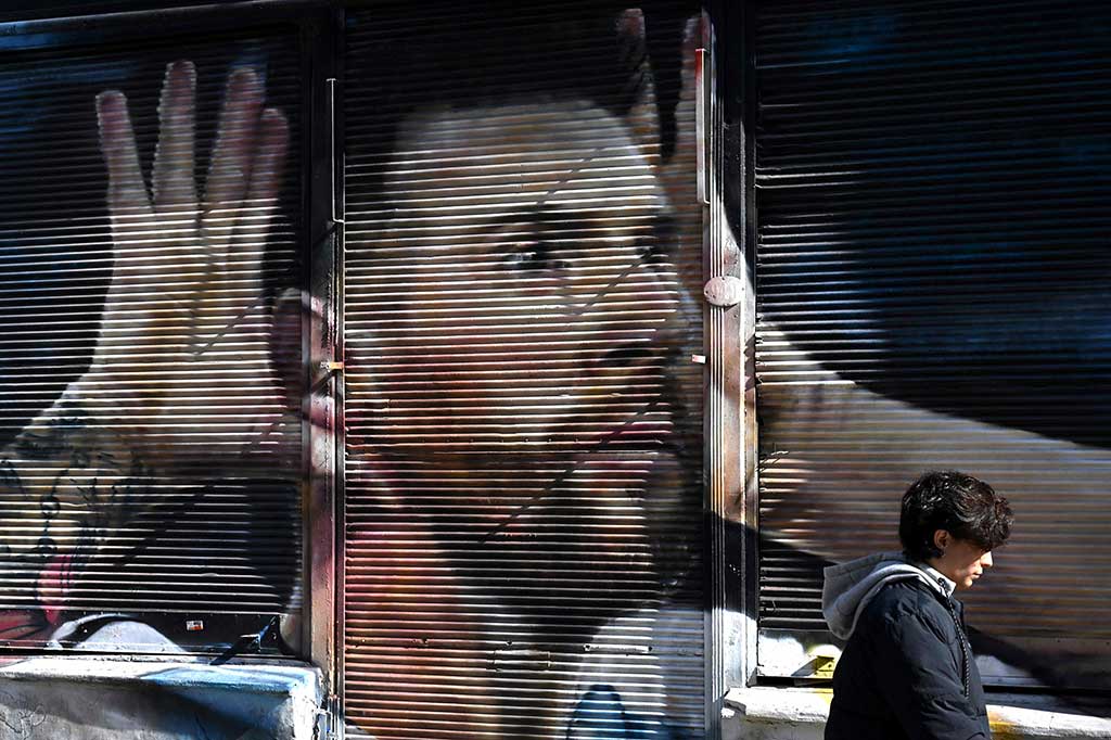 Seorang wanita berjalan melewati tirai bergambar bintang sepak bola Argentina Lionel Messi, di Buenos Aires, pada Selasa, 9 Mei 2023 waktu setempat.