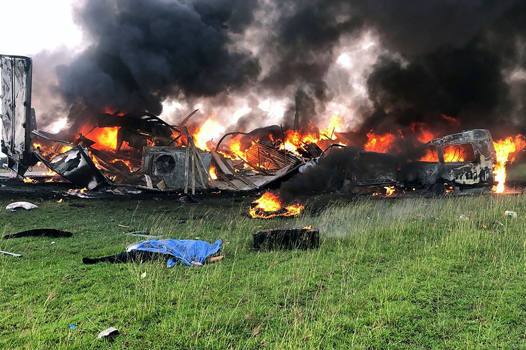 Gambar yang dibagikan oleh pihak berwenang menunjukkan van penumpang hampir seluruhnya hancur akibat terbakar, sementara truk semi juga terbakar parah.