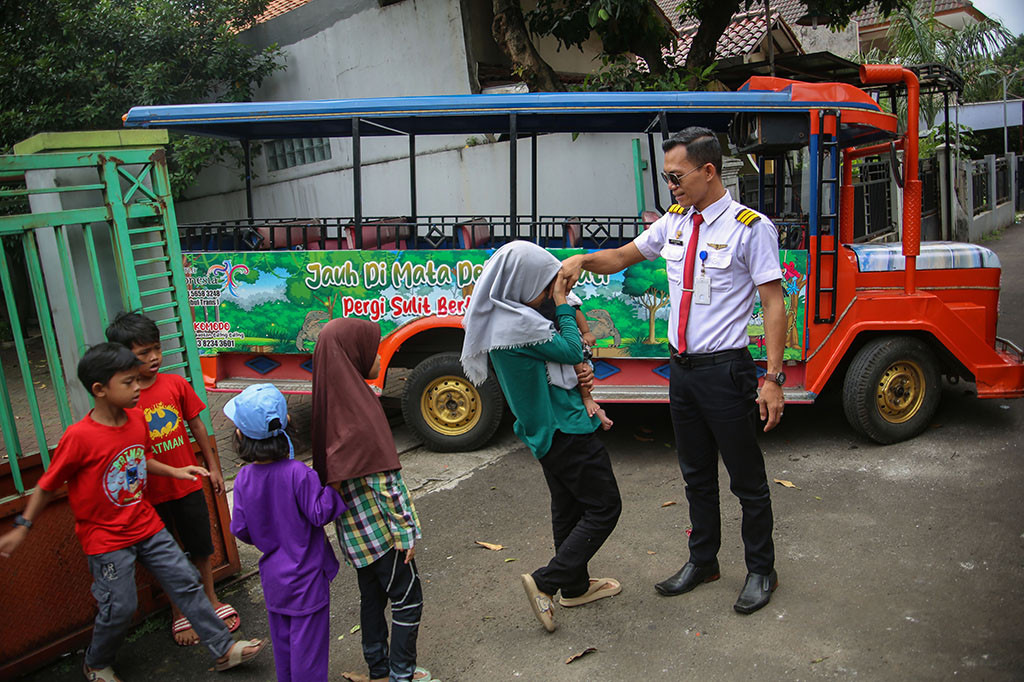 Sopir odong-odong Ari Jambul menyalami keenam anaknya sebelum berangkat menarik odong-odong, di kediamannya di Kampung Sawah Baru, Ciputat, Tangerang Selatan, Banten, Kamis, 11 Mei 2023.