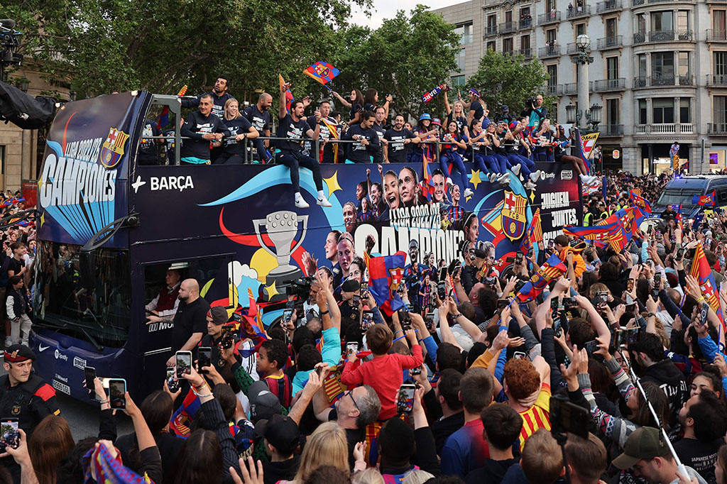Para pemain Barcelona dari tim pria dan wanita dielu-elukan ribuan pendukung di jalan-jalan kota pada Senin, 15 Mei 2023 sore waktu setempat, untuk merayakan dua gelar liga mereka.