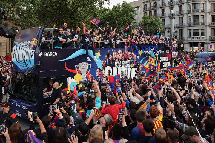 Para pemain Barcelona dari tim pria dan wanita dielu-elukan ribuan pendukung di jalan-jalan kota pada Senin, 15 Mei 2023 sore waktu setempat, untuk merayakan dua gelar liga mereka.